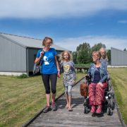 Eelke met vriendin en kinderen voor de rolstoeltoegankelijke bungalow op Provinciaal domein de Gavers
