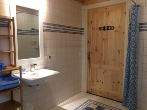 witte tegels, blank houten deur, sfeervol verlicht