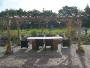 Grote tafel met stoelen onder pergola