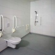 Rolstoeltoegankelijke badkamer, toilet met beugels, Douchehoek zonder drempels met douchestoel
