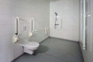 Rolstoeltoegankelijke badkamer, toilet met beugels, Douchehoek zonder drempels met douchestoel