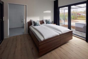 Slaapkamer met twee naast elkaar geplaatste bedden. Aan de raamkant staat een nachtkastje de ruimte aan deze kant is beperkt. Links is voldoende ruimte voor een rolstoel. Daar geen nachtkast maar direct de schuifdeur naar de badkamer
