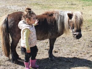 Klein meisje staat bij een shetlandpony